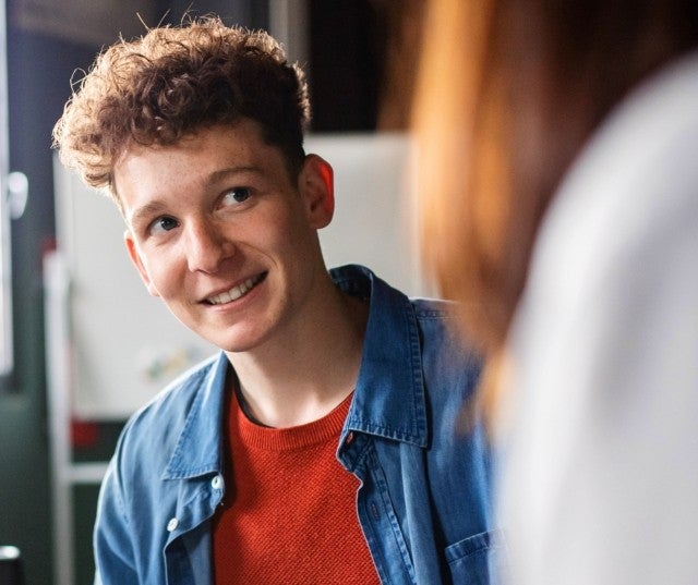 A student smiling in a classroom