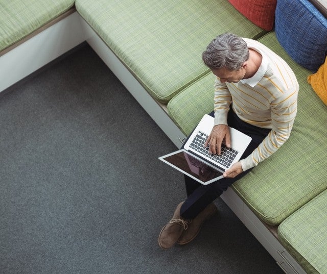 A man uses his laptop in a shared workspace.
