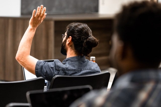 student with raised hand