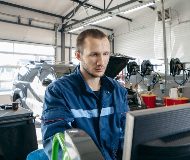 An auto mechanic working on a computer