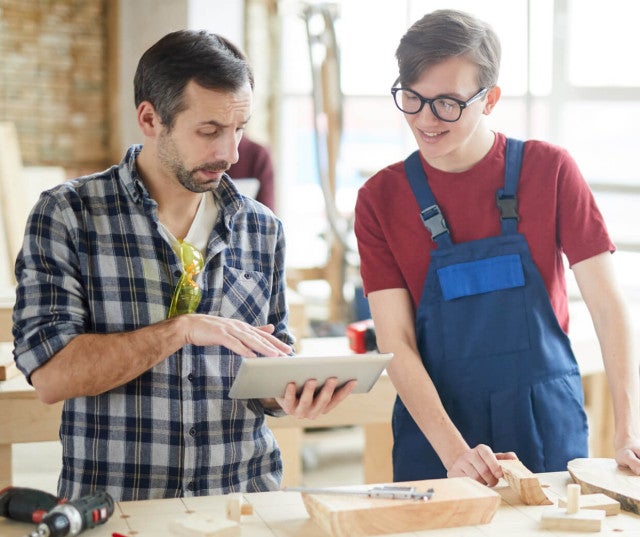 Two co-workers looking at a tablet screen