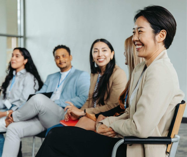 Four people smiling in a meeting